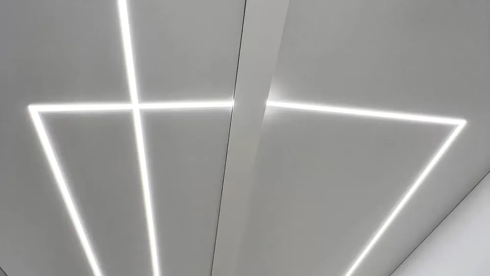White ceiling with geometric recessed light lines