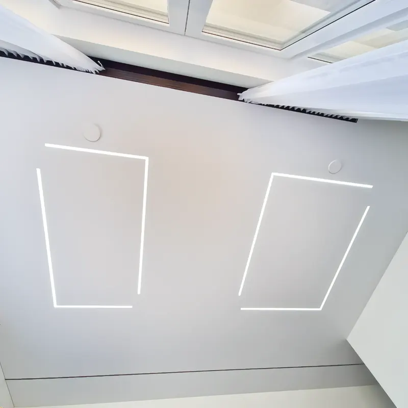 Fabric stretch ceiling with light line frames and a rooflight